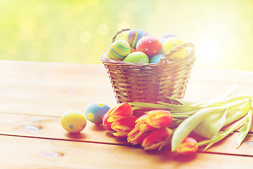 Image showing close up of easter eggs in basket and flowers