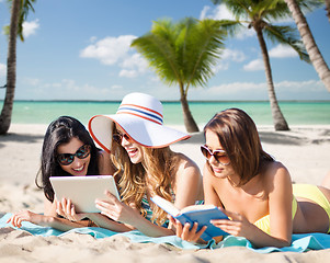 Image showing women with tablet pc and book on summer beach