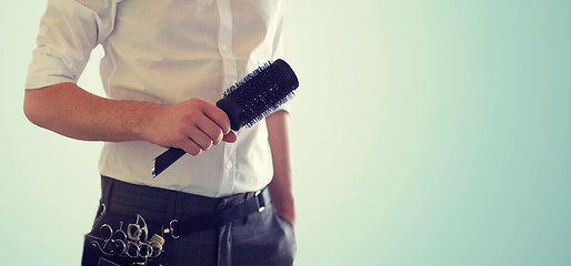 Image showing close up of male stylist with brush at salon