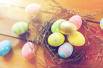 Image showing close up of colored easter eggs in nest on wood