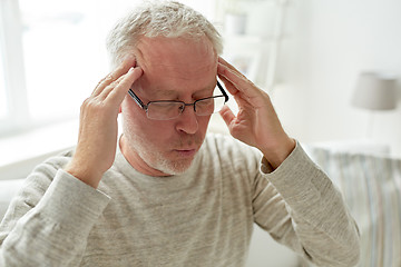 Image showing senior man suffering from headache at home