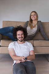 Image showing Young couple on the sofa watching television