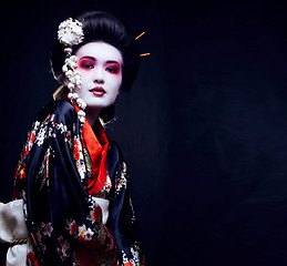 Image showing young pretty geisha in kimono with sakura and decoration