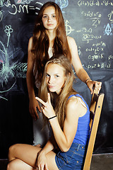 Image showing back to school after summer vacations, two teen girls in classroom with blackboard painted together