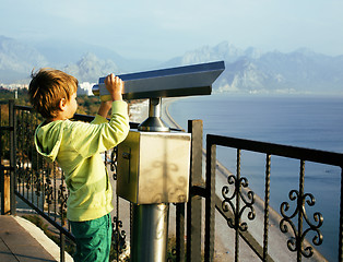 Image showing little cute boy looking through telescope at sea viewpoint in Ataturk park