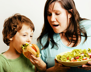 Image showing fat woman holding salad and little cute boy with hamburger teasing