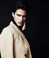 Image showing cool real young man in coat on black background