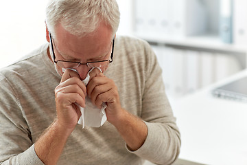 Image showing senior man blowing nose with napkin at hospital