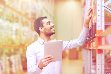 Image showing happy businessman with tablet pc at warehouse