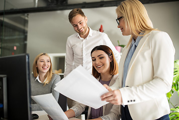 Image showing happy creative team with papers in office