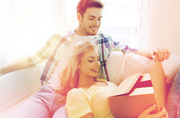 Image showing smiling couple with cardboard box at home