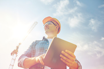 Image showing builder in hardhat with tablet pc at construction