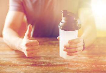 Image showing man with protein shake bottle showing thumbs up