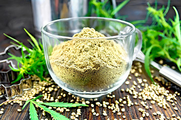 Image showing Flour hemp in glass cup on dark board