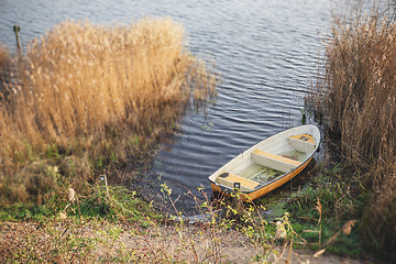 Image showing Yellow fishing boat in a dark lake