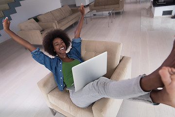 Image showing African American women at home in the chair using a laptop