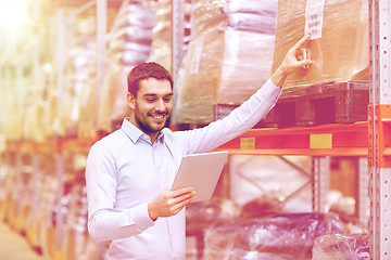 Image showing happy businessman with tablet pc at warehouse