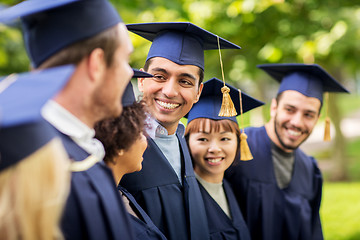 Image showing happy students or bachelors in mortar boards