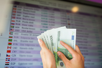 Image showing hands with euro money over currency exchange rates