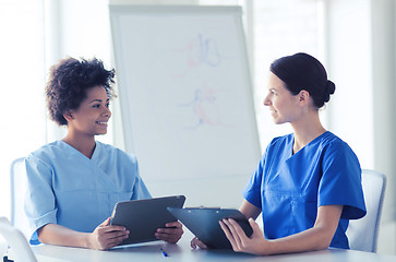 Image showing happy doctors with tablet pc meeting at hospital