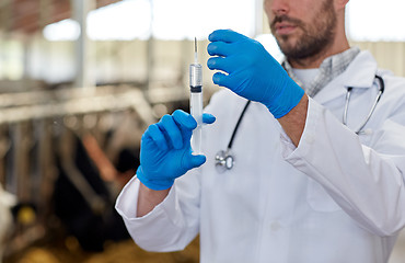 Image showing veterinarian hand with vaccine in syringe on farm