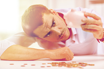 Image showing businessman with piggy bank and coins at office