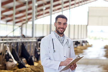 Image showing veterinarian with cows in cowshed on dairy farm