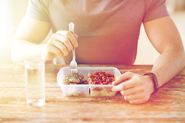 Image showing close up of man with fork and water eating food