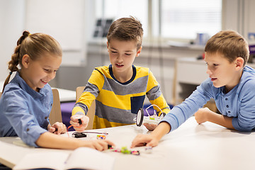 Image showing happy children building robots at robotics school