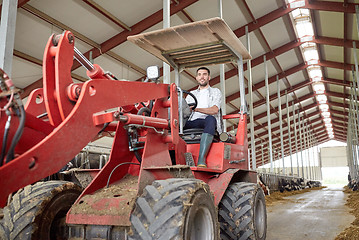 Image showing man or farmer driving tractor at farm