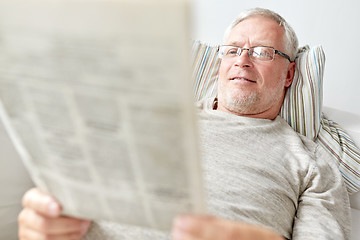 Image showing close up of senior man reading newspaper at home