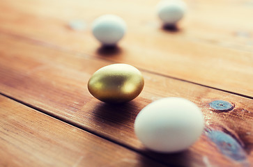 Image showing close up of golden and white easter eggs on wood