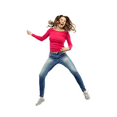 Image showing happy woman jumping and pretending guitar playing