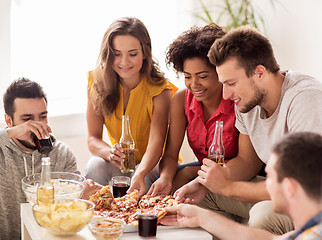 Image showing happy friends with drinks eating pizza at home