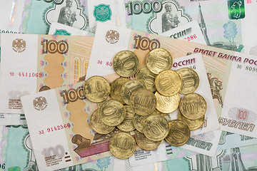 Image showing On randomly scattered banknotes Russian rubles is a bunch of ten-coin