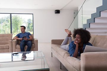 Image showing young multiethnic couple relaxes in the living room