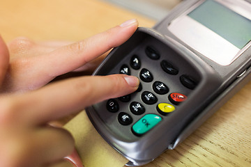 Image showing close up of hand entering code to money terminal