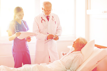 Image showing doctor and nurse visiting senior woman at hospital