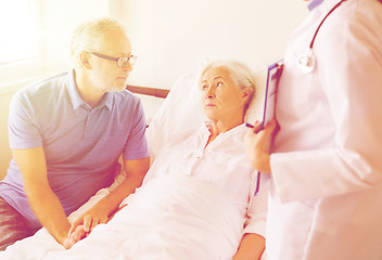 Image showing senior woman and doctor with clipboard at hospital