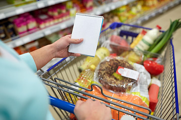 Image showing woman with food in shopping cart at supermarket