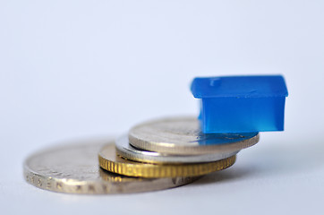 Image showing Little plastic house on metal coins