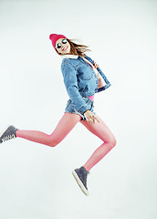 Image showing lifestyle people concept: happy smiling hipster girl jumping on white background isolated