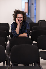 Image showing A student sits alone  in a classroom