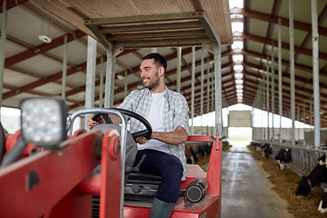 Image showing man or farmer driving tractor at farm