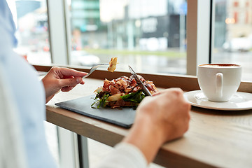 Image showing woman eating prosciutto ham salad at restaurant