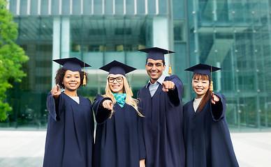 Image showing happy students or bachelors pointing finger at you