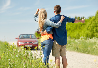 Image showing couple hitchhiking and stopping car on countryside