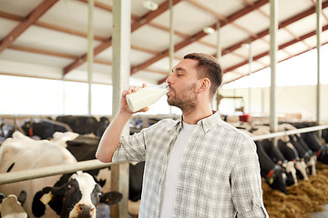 Image showing man or farmer drinking cows milk on dairy farm