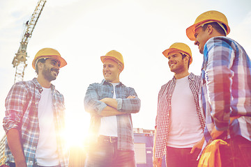 Image showing group of smiling builders in hardhats outdoors