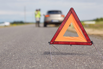 Image showing warning triangle over broken car on road